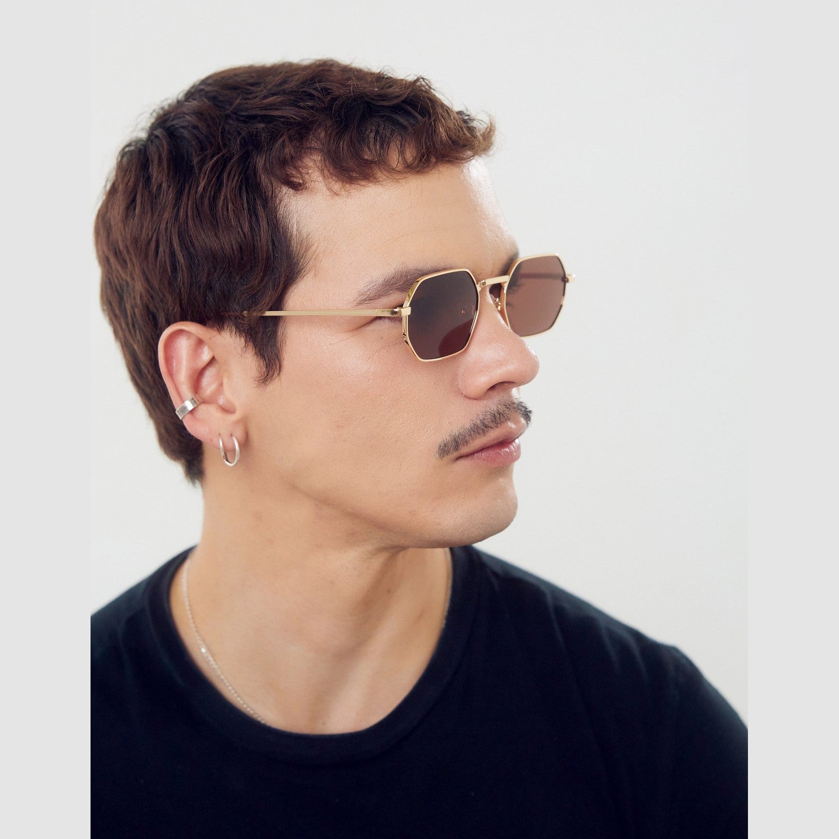 Modelo usando los lentes de sol OSAK de Solivo, mostrando su diseño sofisticado y protección UV400 en un ambiente al aire libre.