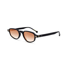 Lentes de sol KIRI de Solivo mostrando un perfil lateral chic, con marco negro y lentes en deliciosa gradación de color naranja, ideal para cualquier ocasión.