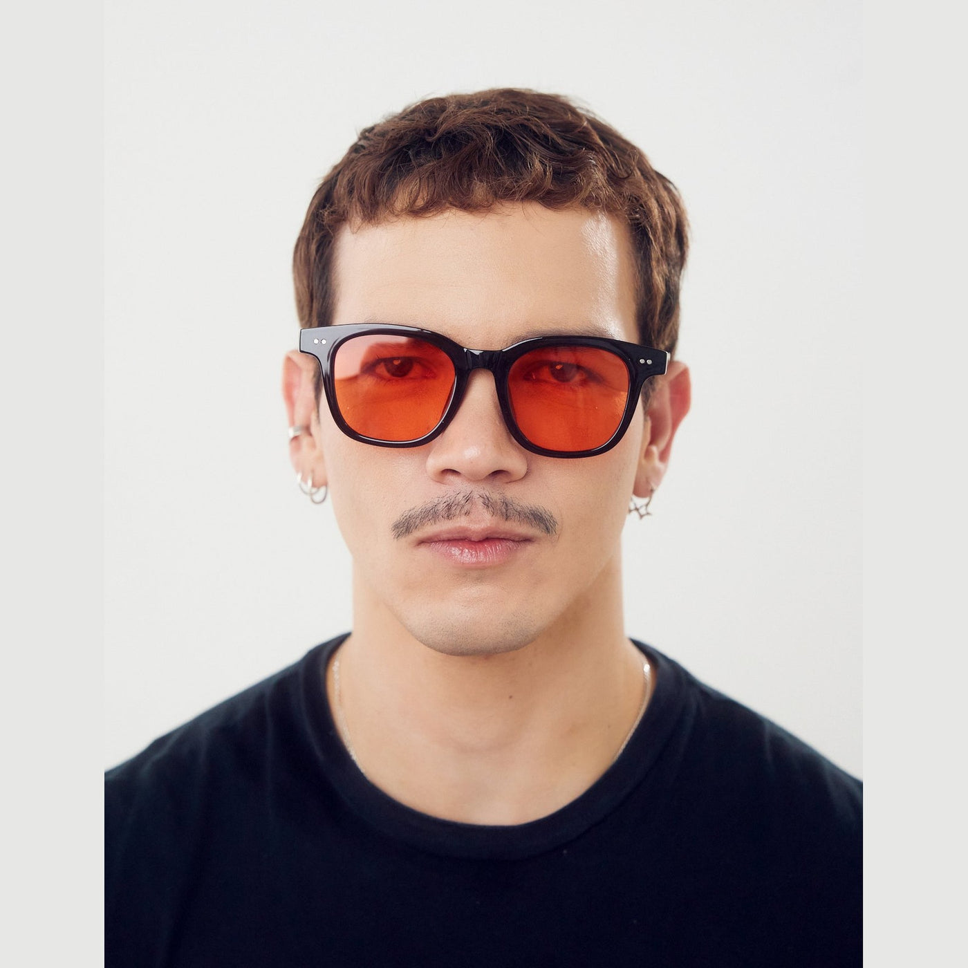 Lentes de sol ACE de Solivo en color negro con efecto atardecer, estilo moderno y elegante, con protección UV400 y lentes en degradado naranja.