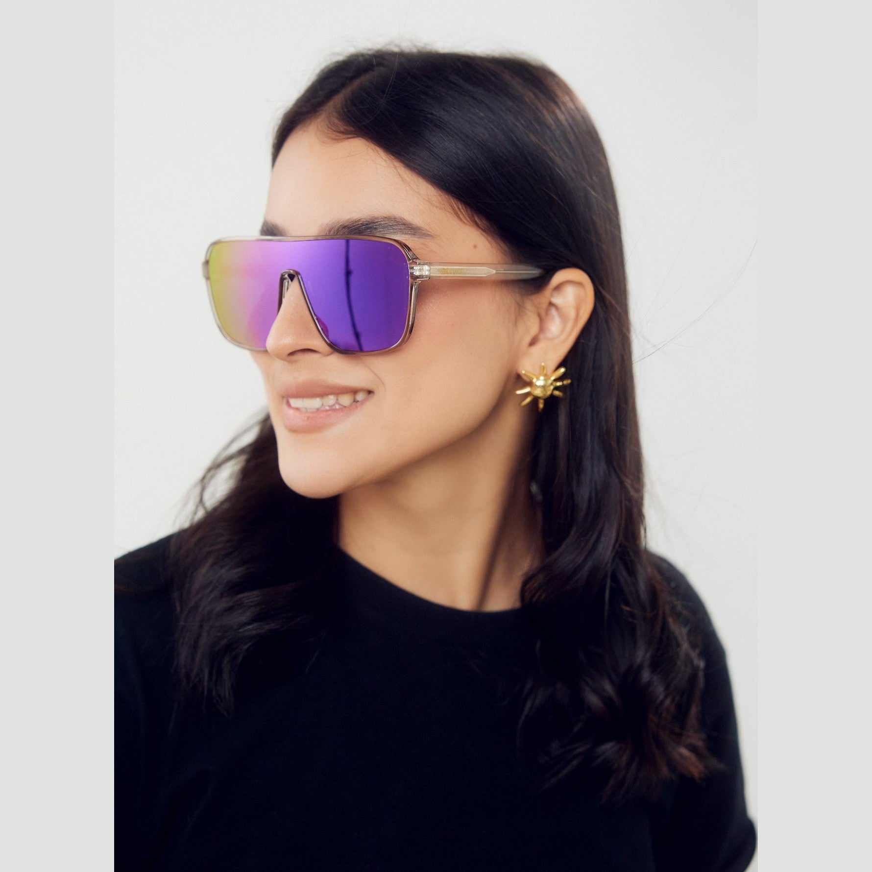 Lentes de sol MIA de Solivo, diseño elegante y moderno en un fondo playero, ideal para protegerse del sol con estilo.